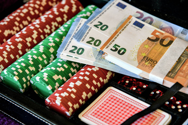 カードやポーカーをプレイするためのチップ。ユーロとドルの紙幣はサイコロとカードにあります. - 写真・画像