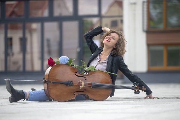 A female musician with a cello on the street - Photo, Image