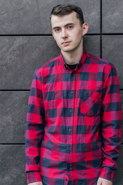 Молодой красивый парень в красной клетчатой рубашке - Фото, изображение