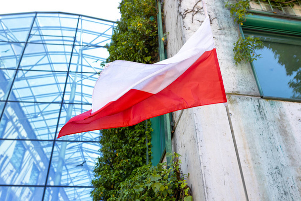 Drapeau de la Pologne sur la façade d'un bâtiment agitant le vent. Symbole du patriotisme national. - Photo, image