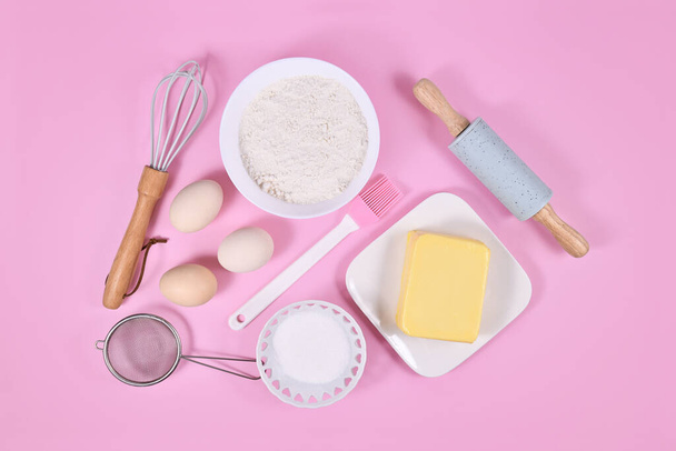 Cake dough ingredients and baking tools on pink background  - Φωτογραφία, εικόνα