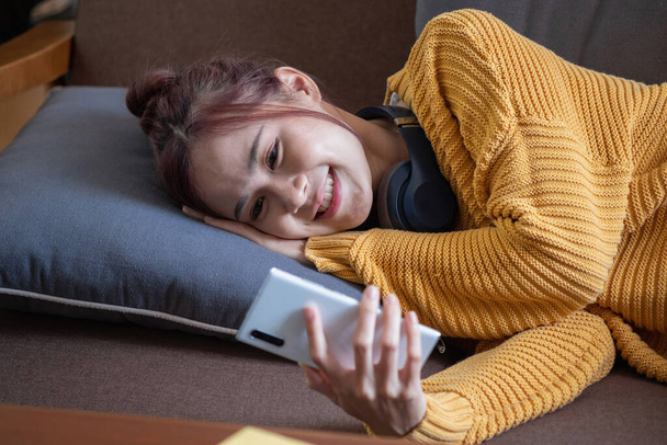 relax, de-stress, holiday, happy, Asian woman relaxing at home listening to music from smartphone and laptop happily. - Photo, image