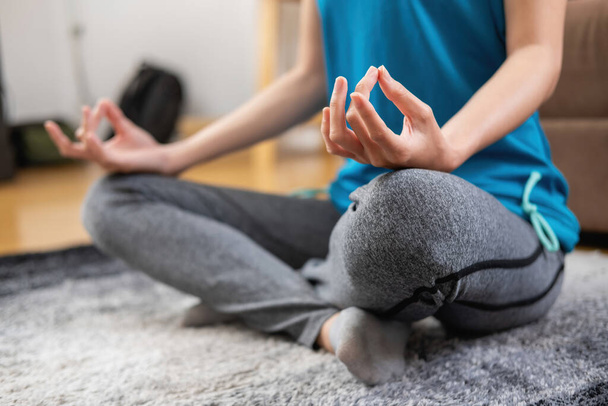 Frau praktiziert Yoga zu Hause von Online-Kursen nach der Arbeit. Stressabbau, Muskelentspannung, Atemübungen, Bewegung, Meditation. - Foto, Bild