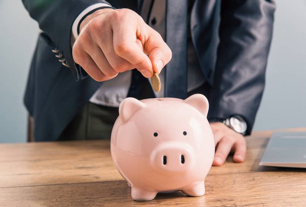 Put coins in piggy piggy bank - savings concep - Фото, изображение