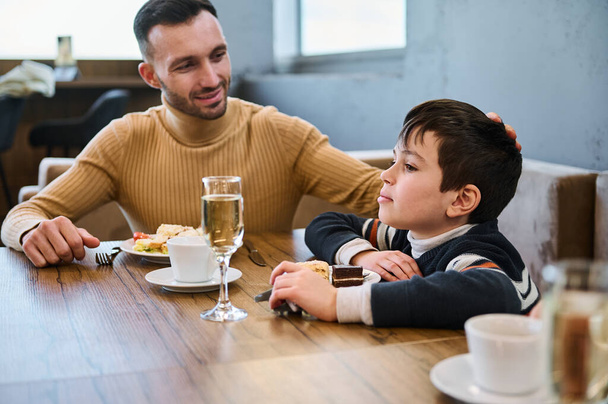 Adorável caucasiano menino em idade escolar com seu pai almoçando juntos na cafetaria - Foto, Imagem