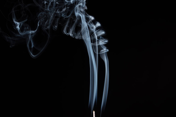 Wierook stokje met rook tegen zwarte achtergrond - Foto, afbeelding