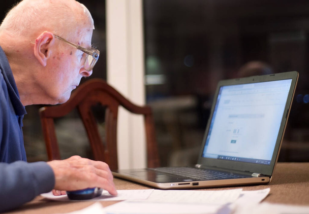 Γέρος 93 ετών που δυσκολεύεται να χρησιμοποιήσει τον υπολογιστή του για να ελέγξει τα οικονομικά του στο διαδίκτυο, πολύ δύσκολο για τους ηλικιωμένους. - Φωτογραφία, εικόνα