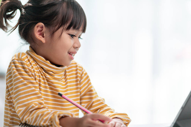 Дитяча самоізоляція, використовуючи планшет для домашнього завдання, Дитина використовує цифровий планшет для пошуку інформації в Інтернеті під час ковадла 19 блокування вниз, домашнє навчання, соціальна відстань, онлайн-освіта
 - Фото, зображення