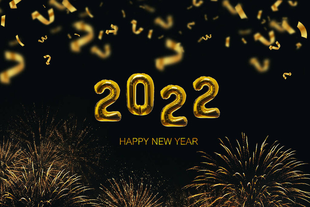 Golden Balloons 2022 New Year's Eve on a black background with gold fireworks and confetti. Luxury golden color. Happy New Year, concept idea. Creative design - Photo, Image