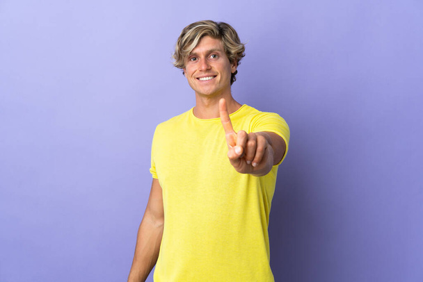 Inglés hombre sobre aislado púrpura fondo mostrando y levantando un dedo - Foto, Imagen