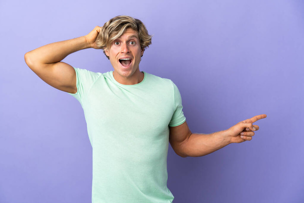 English man over isolated purple background surprised and pointing finger to the side - Foto, immagini