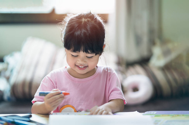 Schattig kinderschilderijtje met kleurrijke verven. Aziatisch meisje met behulp van krijt tekening kleur.Baby kunstenaar activiteit lifestyle concept. - Foto, afbeelding