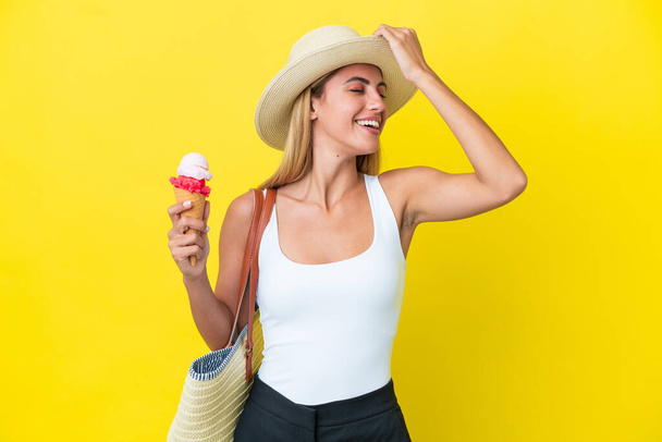 Chica rubia uruguaya en verano sosteniendo helado aislado sobre fondo amarillo se ha dado cuenta de algo y la intención de la solución - Foto, imagen