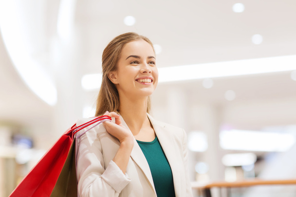 alışveriş merkezinde alışveriş torbaları ile mutlu bir genç kadın - Fotoğraf, Görsel