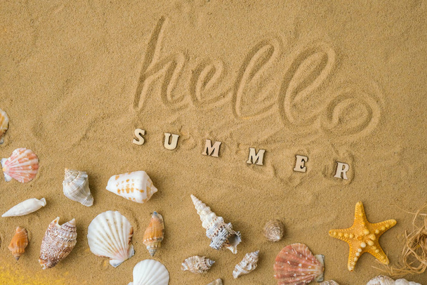 Composition with text HELLO SUMMER seashells, pebbles, mockup on sand background. Blank, top view, still life, flat lay. Sea vacation travel concept tourism and resorts. Summer holidays - Фото, изображение