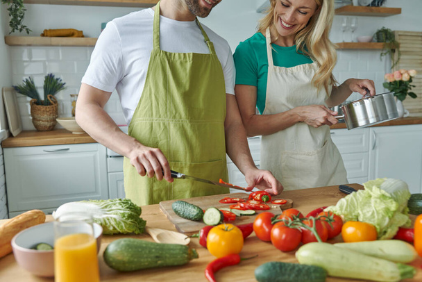 Close-up of young couple cooking together at the domestic kitchen - 写真・画像