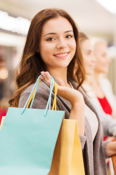 happy young women with shopping bags in mall - Foto, imagen