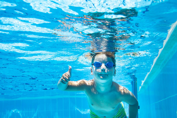 хлопчик плаває під водою басейну
 - Фото, зображення