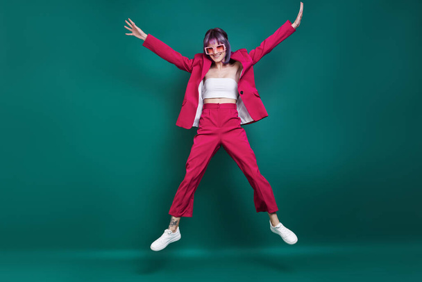 Hipster young woman jumping against green background - Foto, immagini