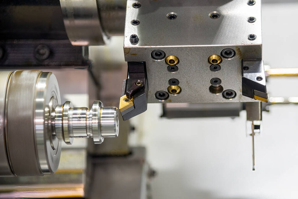 Η διπλή μηχανή τόρνου τύπων CNC που διαμορφώνει την κοπή των μερών άξονα μετάλλων. Η υψηλής τεχνολογίας κατεργασία μετάλλων από CNC γυρίζοντας μηχανή . - Φωτογραφία, εικόνα