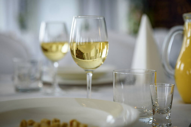 ποτήρια λευκού κρασιού και ένα ποτήρι σαμπάνια στο τραπέζι - Φωτογραφία, εικόνα