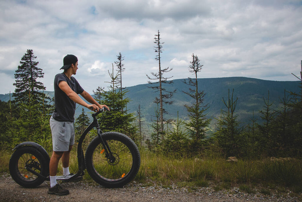 Swarthier Art von Person fährt mit einem Downhill-Mountainbike auf einem steilen Waldweg um einen Berg in Jeseniky Gebirge, Tschechische Republik. Kurort Dolni Morava.  - Foto, Bild