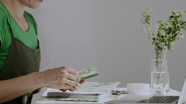 Λευκή γυναίκα μεταξύ 38 και 40 ετών κρατάει σημειώσεις κρατώντας χρήματα στα χέρια της. Αργή κίνηση - Πλάνα, βίντεο