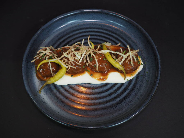Creamy Beef Meatballs with sauce served in a dish isolated on dark background top view - Photo, Image