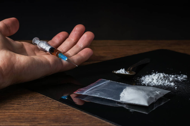 Verslaafde man dood na injectie overdosis met injectiespuit heroïne bij de hand. Sociale ramp en epidemie van het begrip drugsverslaving - Foto, afbeelding