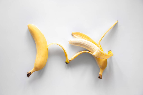 Два банани на білому тлі ізольовані, плоскі, концептуальний мінімалізм
. - Фото, зображення