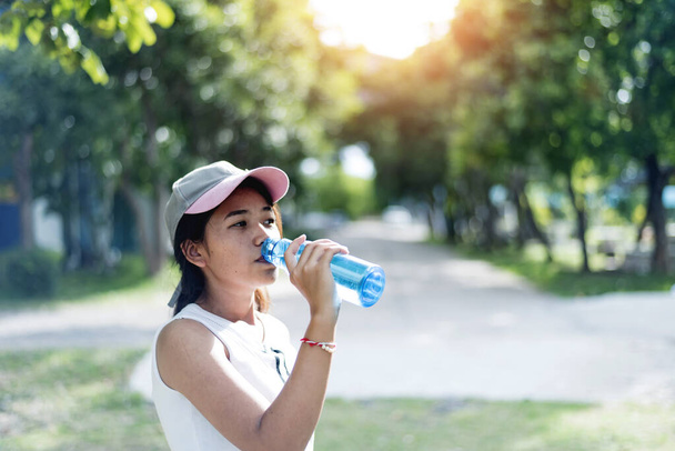 Asiatico giovane donna bere acqua dopo jogging, healty e sport concetto. - Foto, immagini