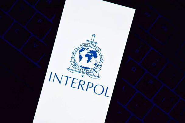 Kharkiv, Ukraine - 16 juin 2022 : Un smartphone avec le logo Interpol affiché à l'écran se trouve sur le clavier. Organisation internationale de police criminelle ou Interpol. - Photo, image