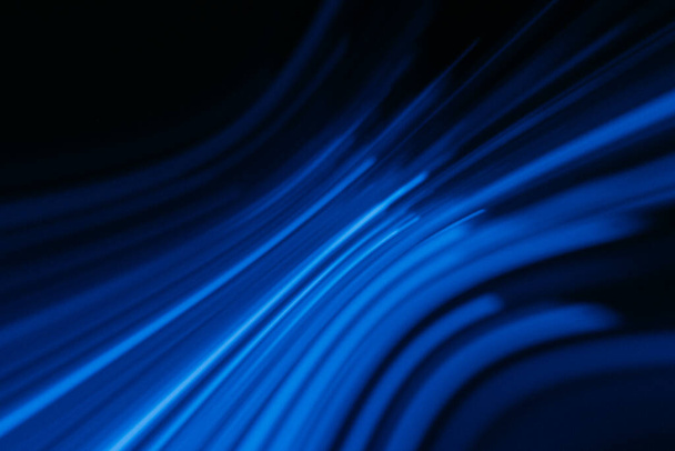 Defocused glowing lines. Neon light flare. Cyber illumination. Blur luminous navy blue color curve rays glare motion on dark black modern abstract background. - Zdjęcie, obraz