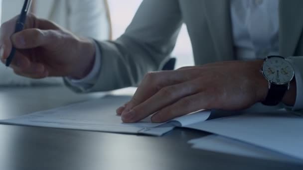 Man hand signing papers in office closeup. Insurance client checking agreement in suit. Unrecognized financial partners managers concluding successful deal. Business people meeting partnership concept - Séquence, vidéo
