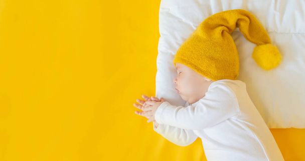 Baby sleeps on a yellow background. Selective focus. People. Merry Christmas and Happy New Year, Holidays greeting card background. Selective focus. - Photo, Image