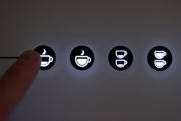 Finger pressing espresso button in automatic coffee machine. High quality photo - Fotografie, Obrázek