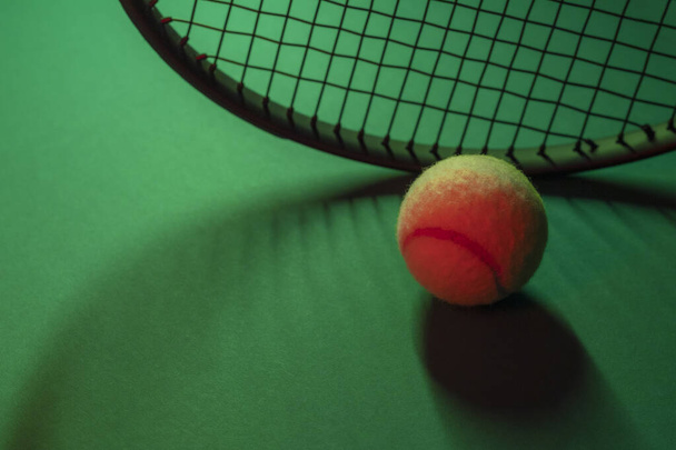 Top kilátás teniszütők és labda a zöld háttér. Horizontális sportplakát, üdvözlőlapok, fejlécek, weboldal - Fotó, kép