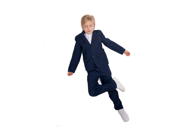 Schoolboy in classic suit isolated on white background. Blond boy with closed eyes. Full length portrait of boy in school uniform - Photo, Image