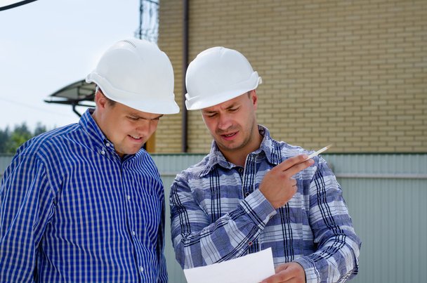 Two builders or engineers discussing paperwork - Fotografie, Obrázek