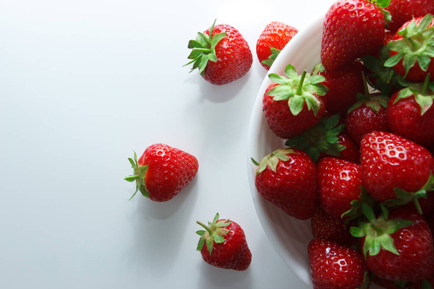 Red ripe strawberry in the white bowl, light background - Photo, Image