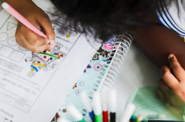 Szczegóły malowania rąk ucznia z kolorowymi ołówkami. Salvador, Bahia, Brazylia. - Zdjęcie, obraz