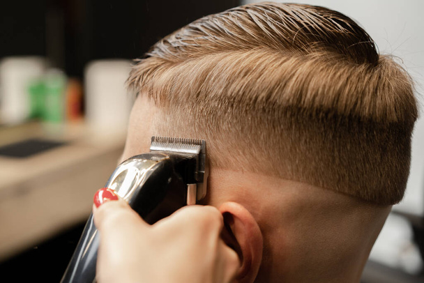 Barbershop, close-up: a woman hairdresser cuts hair with a razor - Foto, imagen