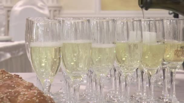 champagne wordt uit een fles gegoten, in champagneglazen in slow motion. - Video