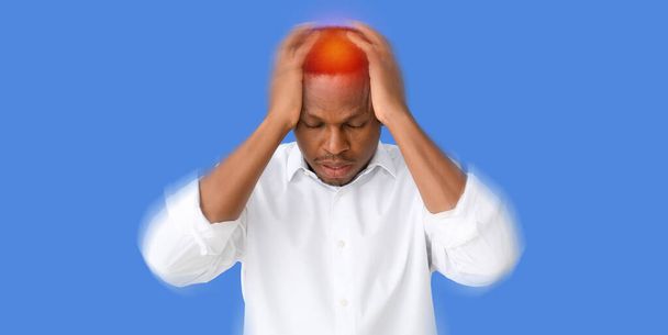 Αφροαμερικάνος με πονοκέφαλο σε μπλε φόντο - Φωτογραφία, εικόνα