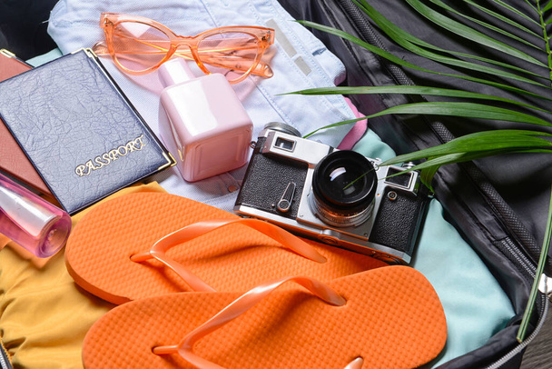Vrouwelijke accessoires voor reizen en fotocamera in geopende koffer, close-up - Foto, afbeelding