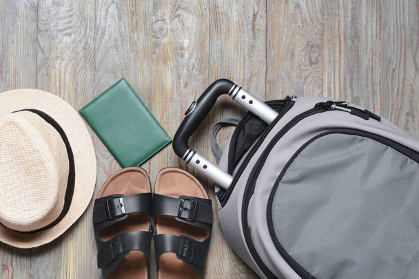Příslušenství pro cestování a batoh na šedém dřevěném pozadí - Fotografie, Obrázek