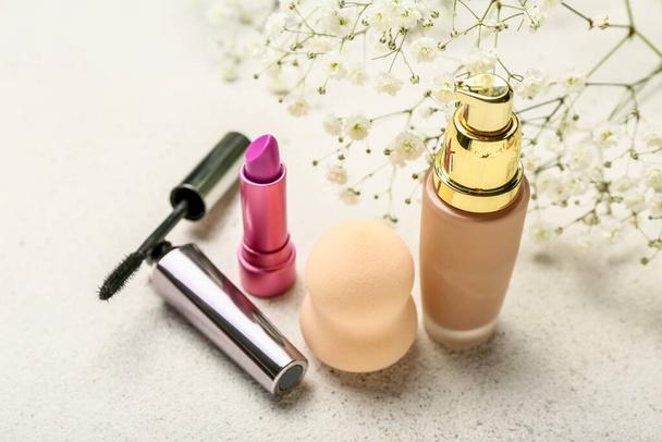 Cosmetics, makeup sponge and gypsophila flowers on light background - Photo, Image