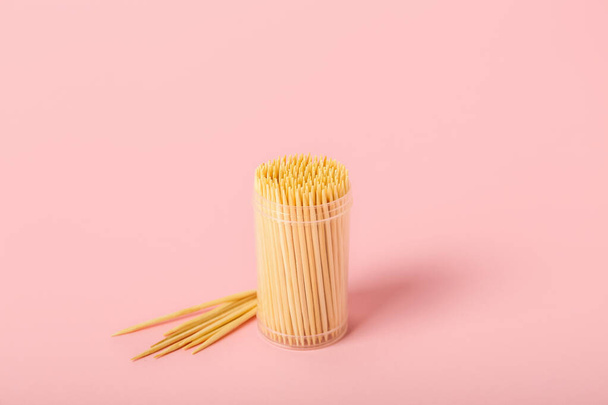 Box with wooden toothpicks on pink background - Foto, Bild