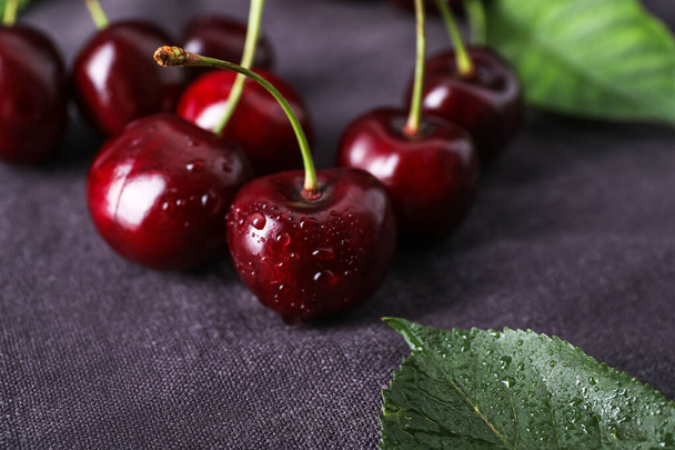 Ripe cherries with water drops on fabric background, closeup - Foto, imagen