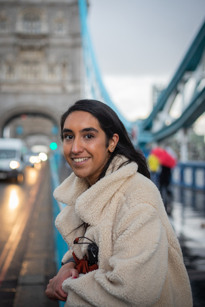 portré egy mosolygós lányról, aki Londonban áll a Tower Bridge-en. - Fotó, kép